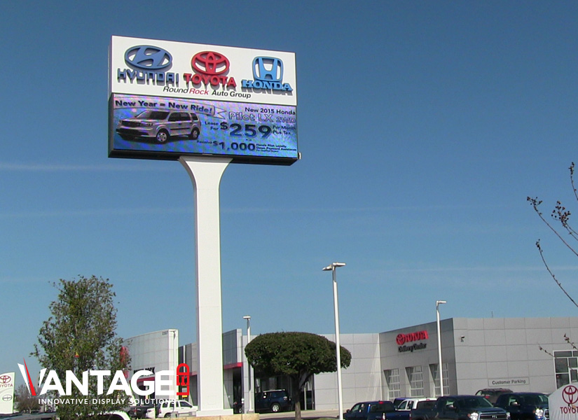 This highway installation with an integrated LED display promotes multiple brands sold by the dealership to bring a wide variety of potential customers into the store.